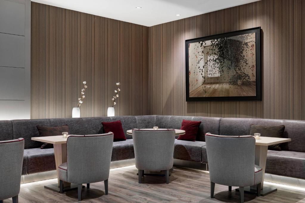 ボローニャにあるAC ホテル ボローニャ ア マリオット ライフスタイル ホテルのテーブルと椅子とソファのあるレストラン