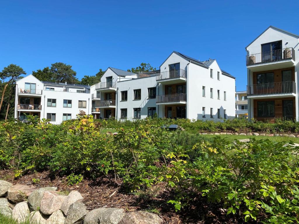 a row of white apartment buildings on a hill at Ferienwohnung Ostseewind 10 Parkvillen Carlota und Candela Baabe in Baabe