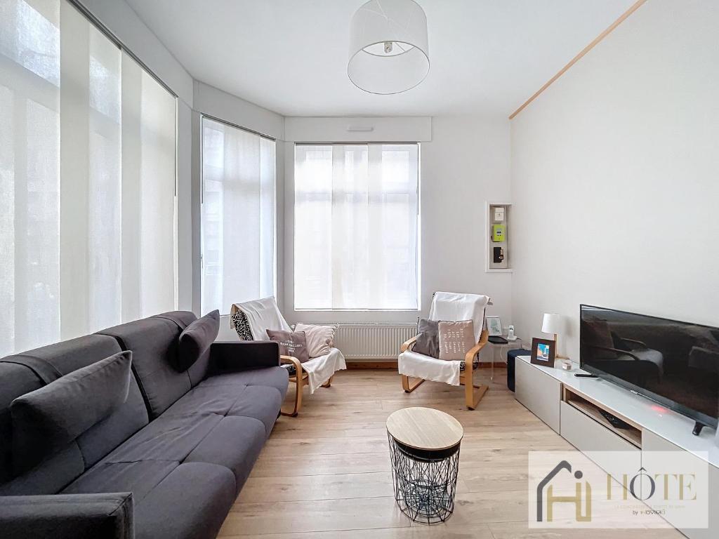 un salon avec un canapé et une télévision dans l'établissement La Petite Malouine - 200m plage, à Dunkerque