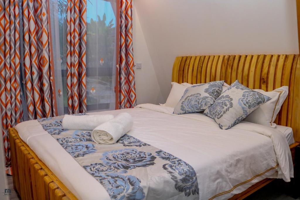 un lit dans une chambre avec une fenêtre dans l'établissement Topi Cottages, à Nanyuki