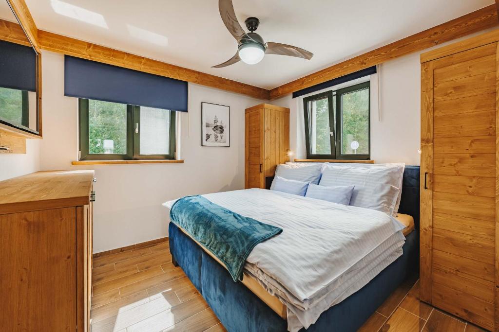 a bedroom with a bed and a ceiling fan at Rezidence KUPEC in Frymburk