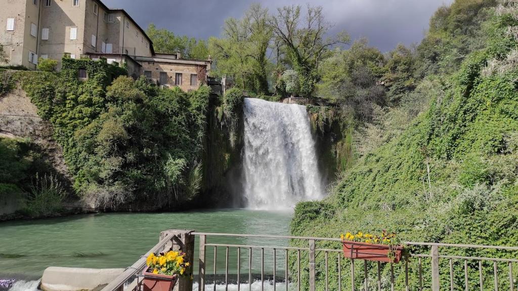 a waterfall on a hill next to a river at Alloggio Turistico di Paolo Trombetta in Isola del Liri