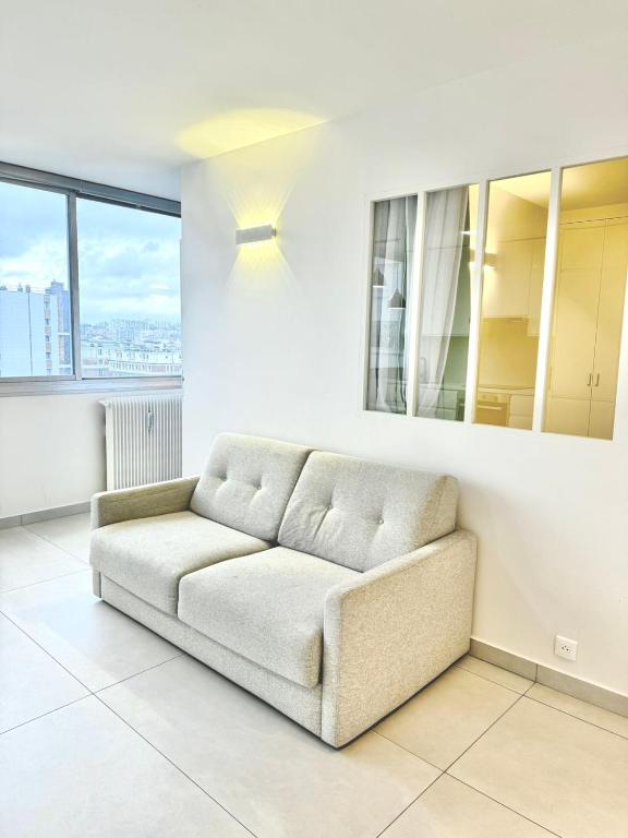 - un salon blanc avec un canapé et des fenêtres dans l'établissement Modern Parisian flat Quartier asiatique Choisy, à Paris