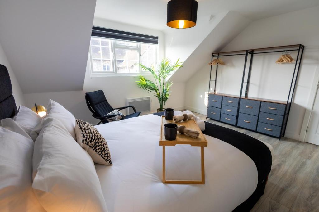 Un dormitorio con una cama grande y una mesa. en Watford Quality 3-bedroom Flat, en Watford