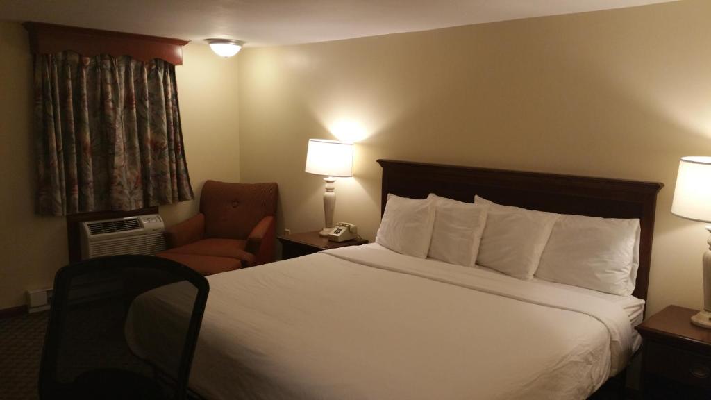 a hotel room with a bed and a chair at Dartmouth Motor Inn in North Dartmouth