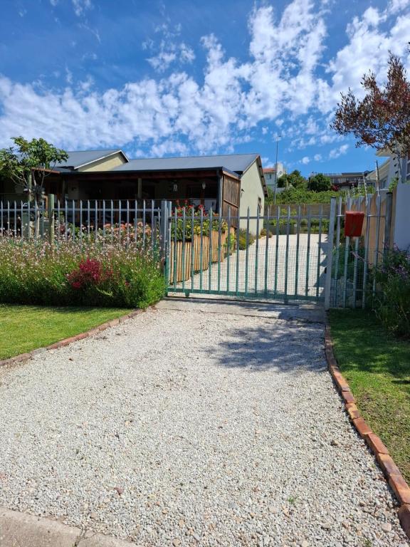 a gate in front of a house at Petite Cottage Plett in Plettenberg Bay