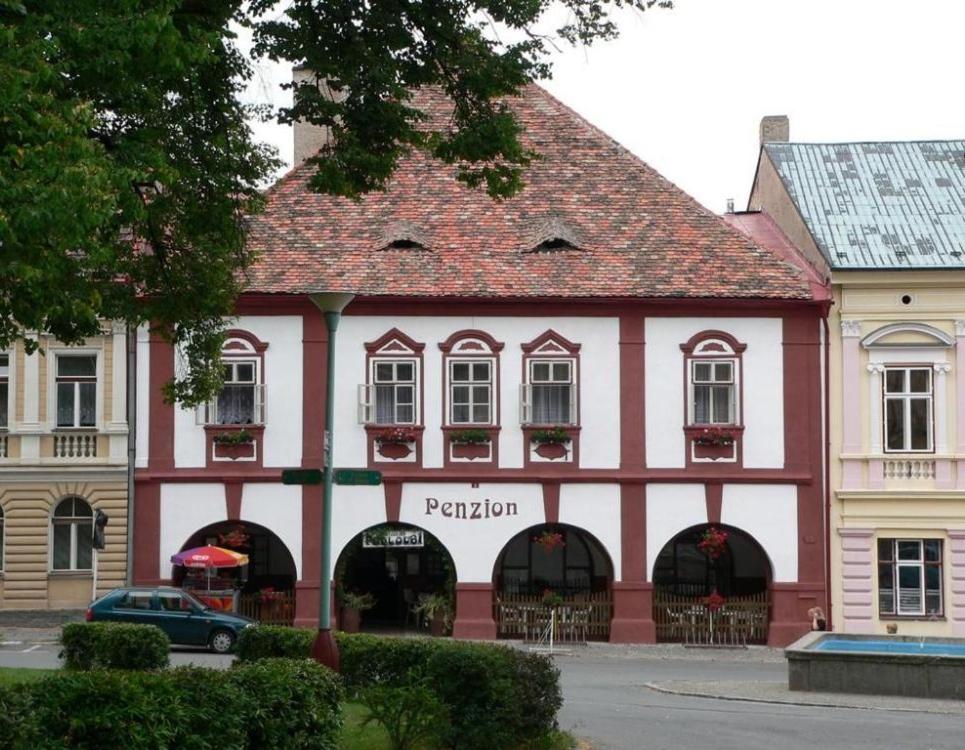a red and white building with a red roof at Restaurace a Penzion Podloubí in Opočno