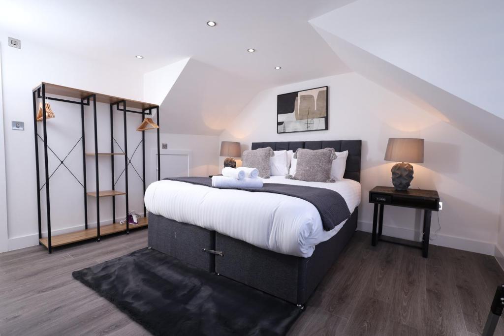 a bedroom with a large bed with white sheets at Spacious 4Bedroom Apartment at Prime Market Street, Watford in Watford