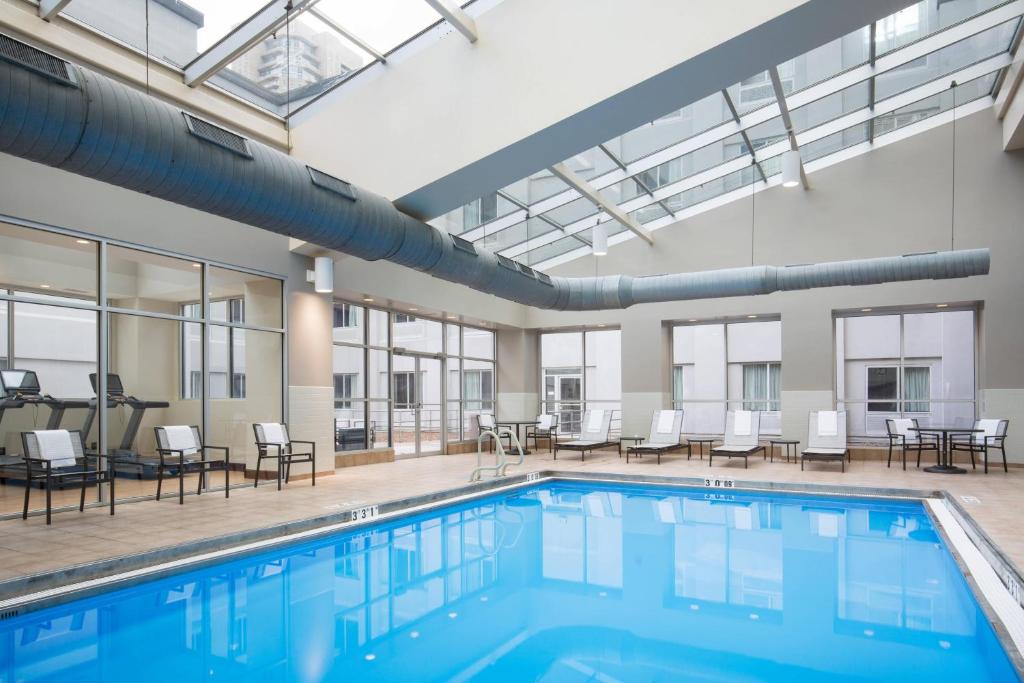 a pool in a building with chairs and tables at AC Hotel Chicago Downtown in Chicago