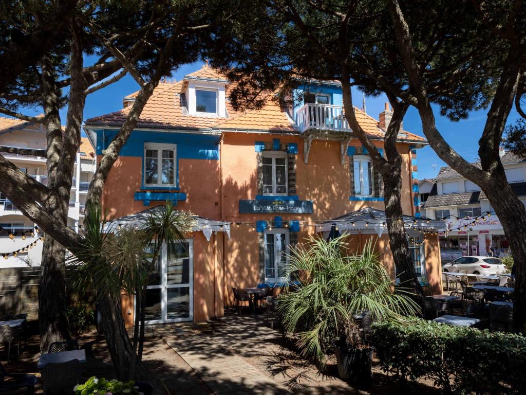 ein orangefarbenes Gebäude mit Bäumen davor in der Unterkunft La Villa Rose-Marie in Saint-Brevin-les-Pins