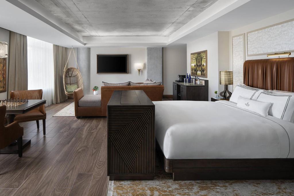 a hotel room with a large bed and a living room at The Ben, Autograph Collection in West Palm Beach