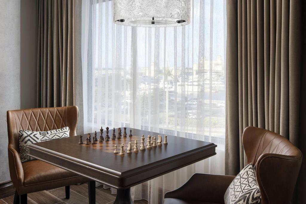 a chess board on a table in a room with a window at The Ben, Autograph Collection in West Palm Beach