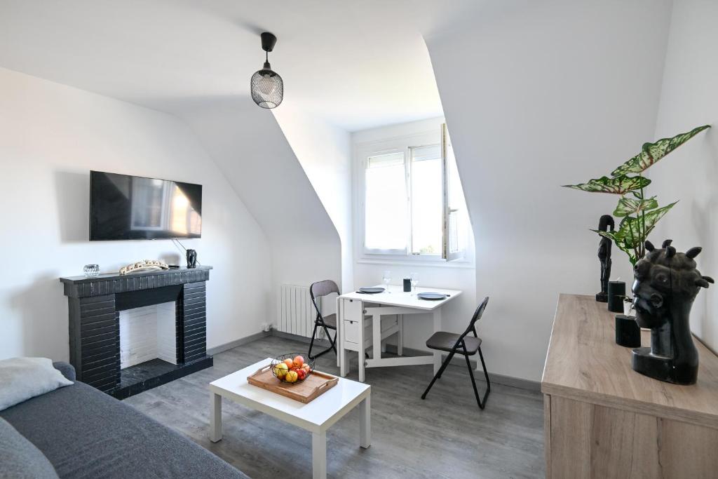 - un salon avec un lit et une table dans l'établissement L'Évasion Normande - Appt à proximité de la plage, à Ouistreham