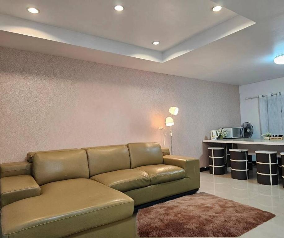 a living room with a couch and a kitchen at ทาวเฮ้าส์ทั้งหลังใกล้สนามบินดอนเมือง 15 นาที in Ban Wat Pho Thong