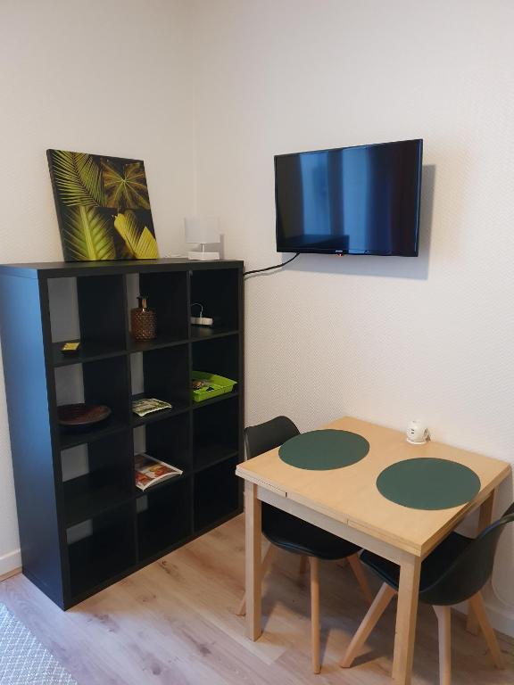 une chambre avec une table et une étagère noire dans l'établissement Studio Cosy, idéalement situé, à Vichy