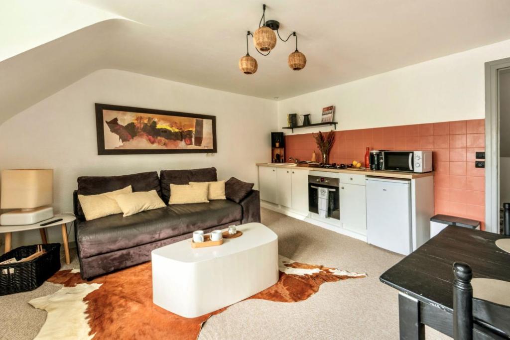 een woonkamer met een bank en een tafel bij Le Charmant in Lannion