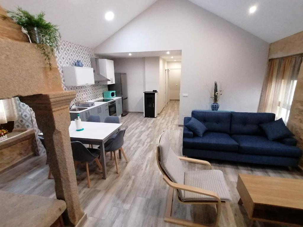 a living room with a blue couch and a table at Casa da Corna by Cristian&Tamara "alquileres" in Pobra do Caramiñal