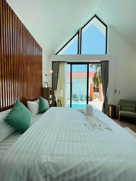 a bedroom with a large bed with a large window at Kaija Resort in Ko Larn
