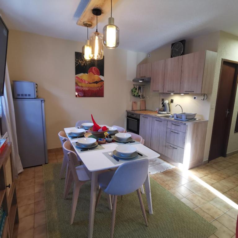 Il dispose d'une cuisine avec une table et des chaises blanches. dans l'établissement Les Campanules-Centre station, à Risoul