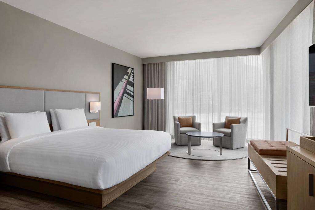 a hotel room with a bed and a table and chairs at AC Hotel by Marriott Cape Town Waterfront in Cape Town