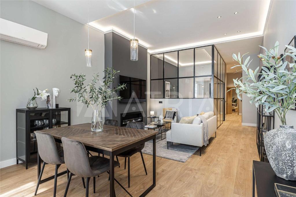 a dining room and living room with a table and chairs at Designer apartment 2 in Madrid