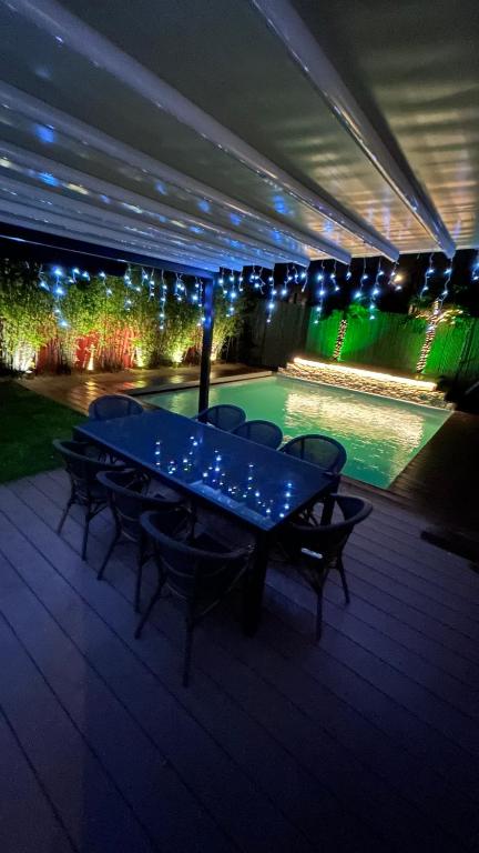 une terrasse avec une table, des chaises et des lumières. dans l'établissement Villa avec Piscine - 15 ' JO - Vélos - 30 ' Disney, à Saint-Maur-des-Fossés