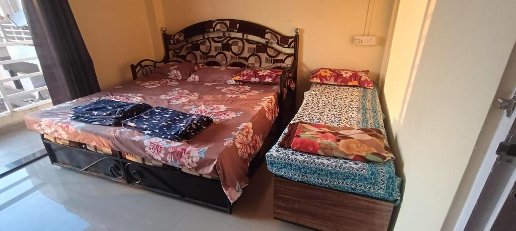 a bedroom with a bed and a twin bed with a bench at B-5 Sea Vista Apartment Dream Home in Ratnagiri