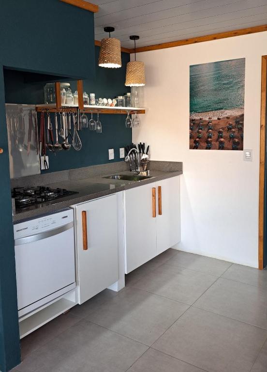 a kitchen with white cabinets and a sink at Casa CRETA - Hermenegildo in Santa Vitória do Palmar