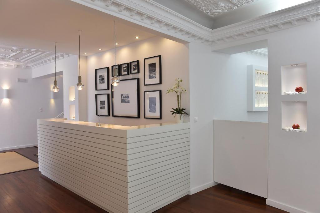 a white counter in a room with pictures on the wall at Apollon Boutique Hotel in Parikia