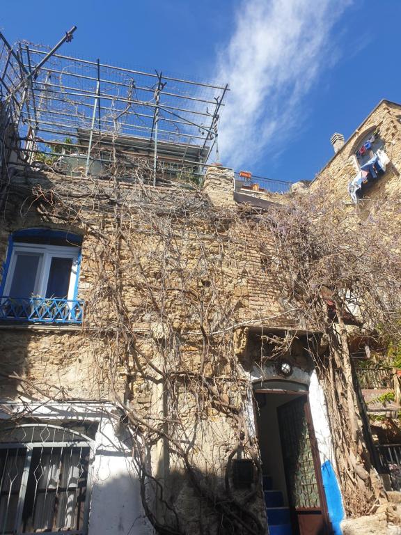 ein altes Steingebäude mit einem Baum davor in der Unterkunft Casa di ingrida Bussana Vecchia in Sanremo