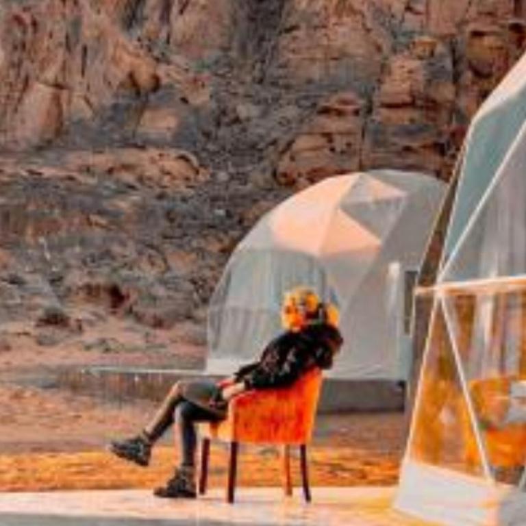 una persona seduta su una sedia su un palco di Traditions of Wadi Rum camp & jeep tour a Wadi Rum