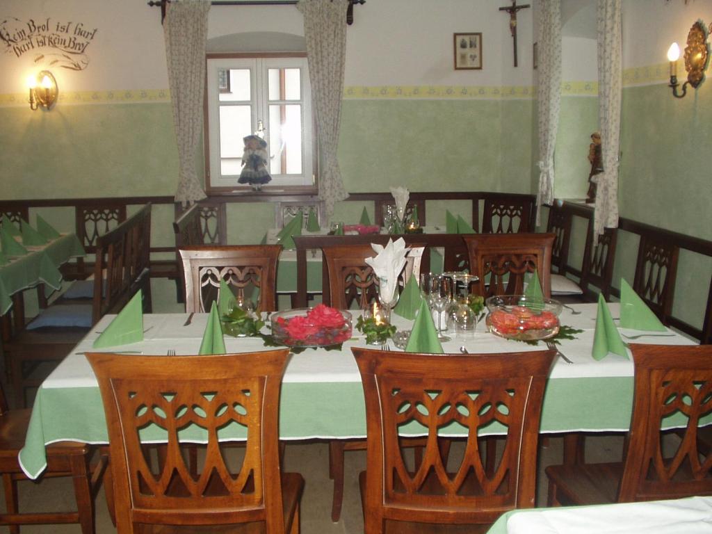 a dining room with a long table with green table cloth at Erlachmühle in Mondsee