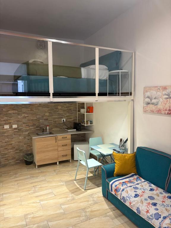 a living room with a blue couch and a kitchen at Appartamento indipendente al centro di Catania in Catania