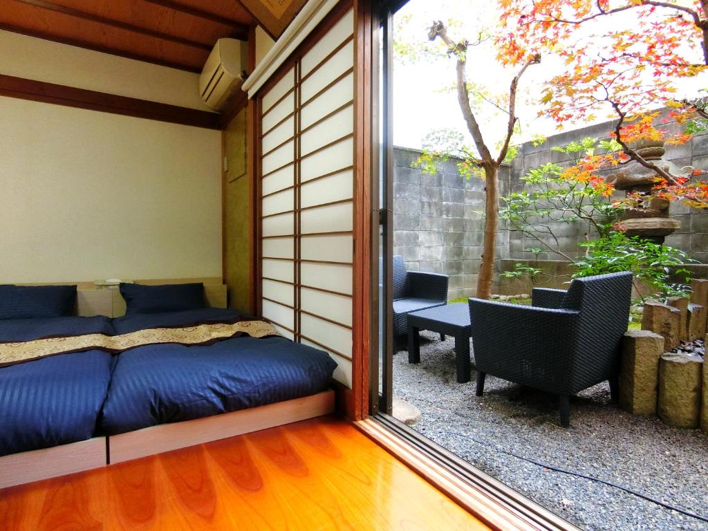 a room with a bed and a sliding glass door at Yuririan in Kyoto
