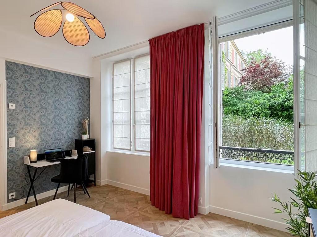 Un dormitorio con una ventana con una cortina roja. en Le Grand Carré Versailles, en Versalles