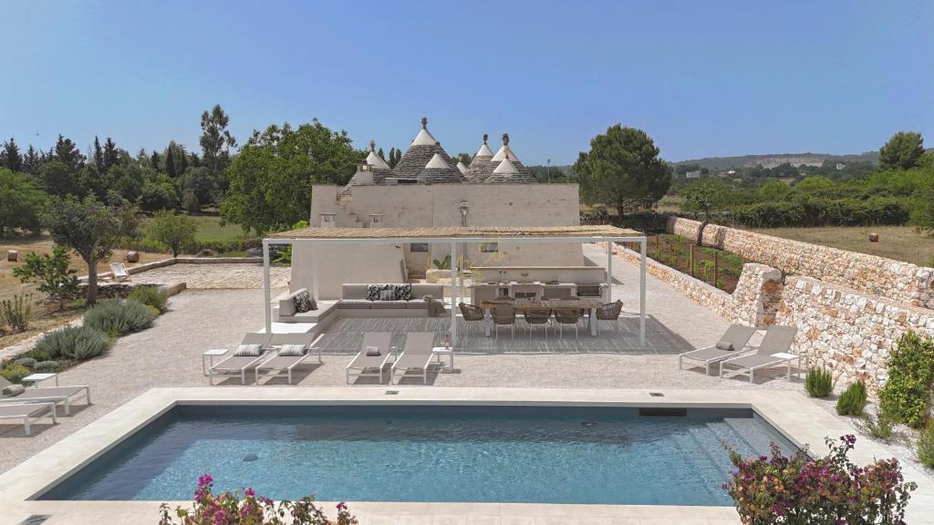 une villa avec une piscine et un bâtiment dans l'établissement TD I Coni di Pinurè Trulli with Scenic Valley View, à Martina Franca