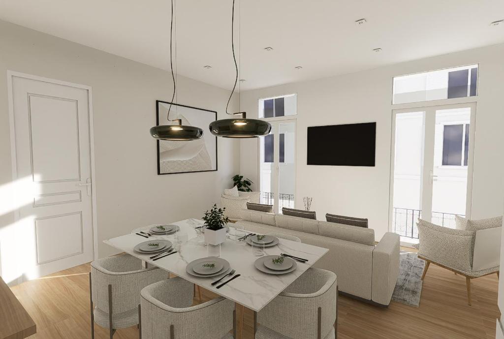 une salle à manger blanche avec une table et des chaises dans l'établissement Étoiles et Lumières de Cannes, à Cannes