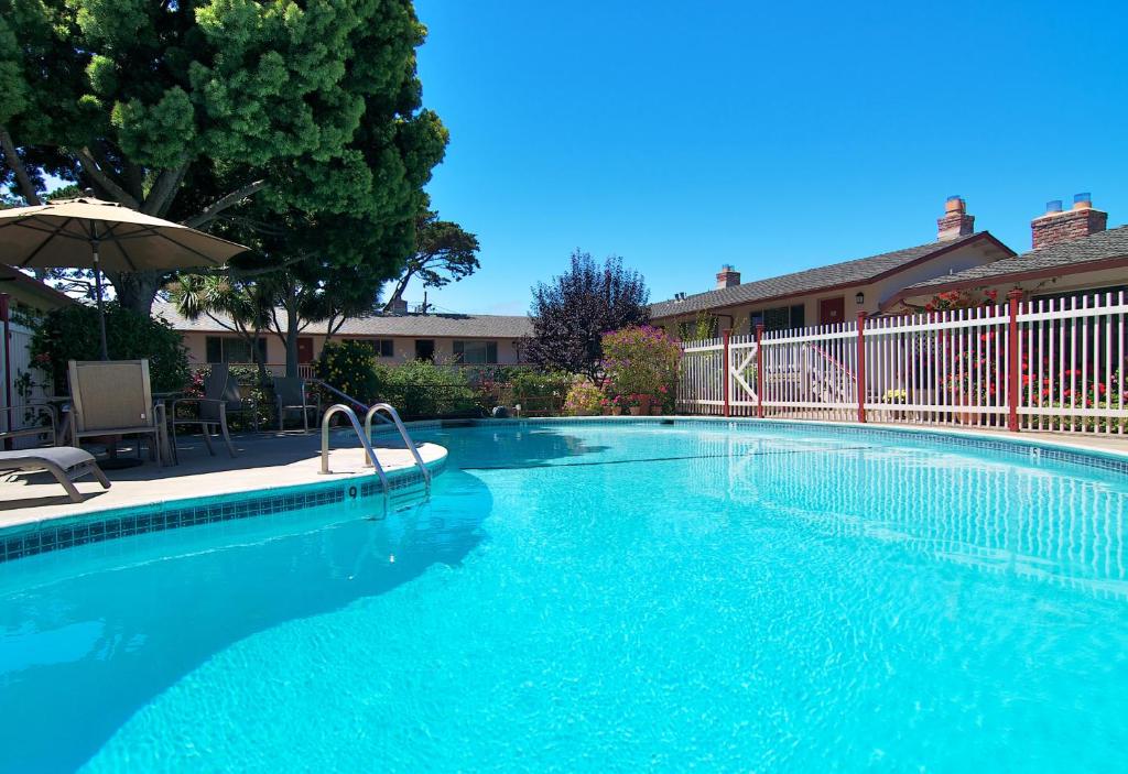 una grande piscina blu con ombrellone di Svendsgaard's Inn a Carmel