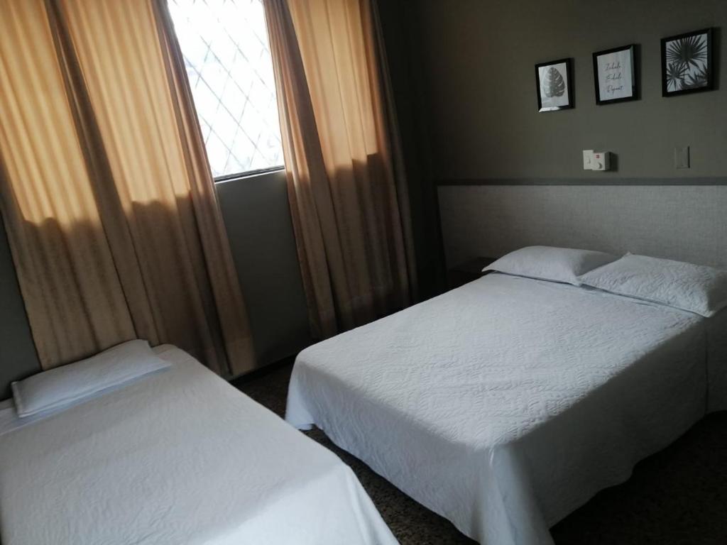 Postel nebo postele na pokoji v ubytování HOTEL MELGAR PLAZA