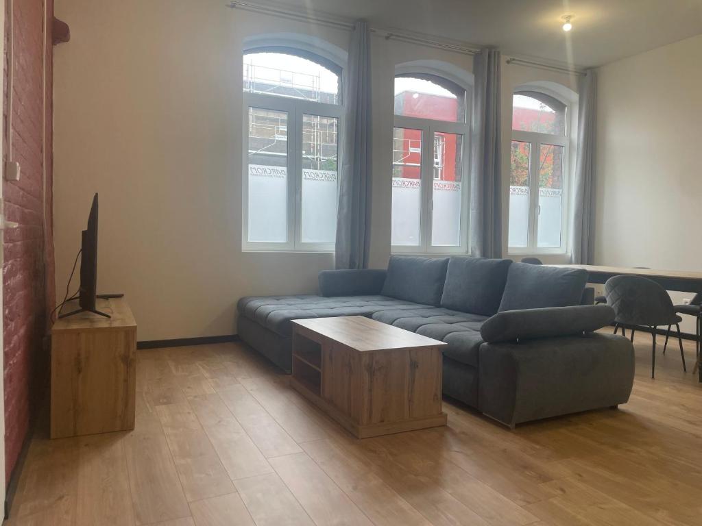 un salon avec un canapé bleu et une table dans l'établissement Victor Hugo 2, à Roubaix