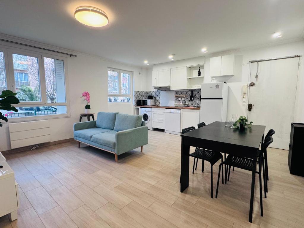Il dispose d'une cuisine et d'un salon avec une table et une chaise bleue. dans l'établissement Grand F4 Rueil proche Paris et RER A Calme et Confort au Coeur de la Ville, à Rueil-Malmaison