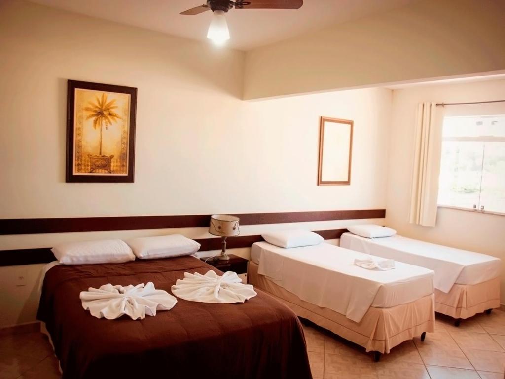 a room with two beds and a window at Hotel Pais e Filhos in São João del Rei