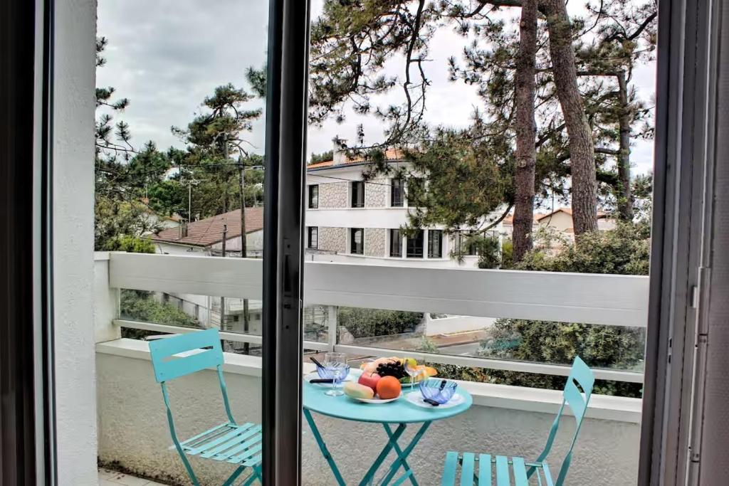 une table et deux chaises sur un balcon avec vue dans l'établissement Escale à la mer, plage de Royan à pied et balcon, à Saint-Georges-de-Didonne