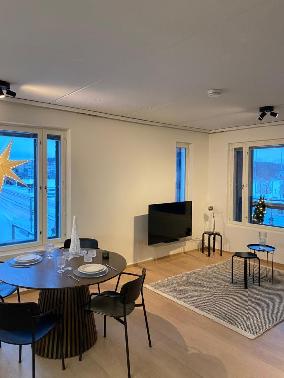 a living room with a table and a flat screen tv at Saunallinen Lutakon kaksio järvinäkymin in Jyväskylä