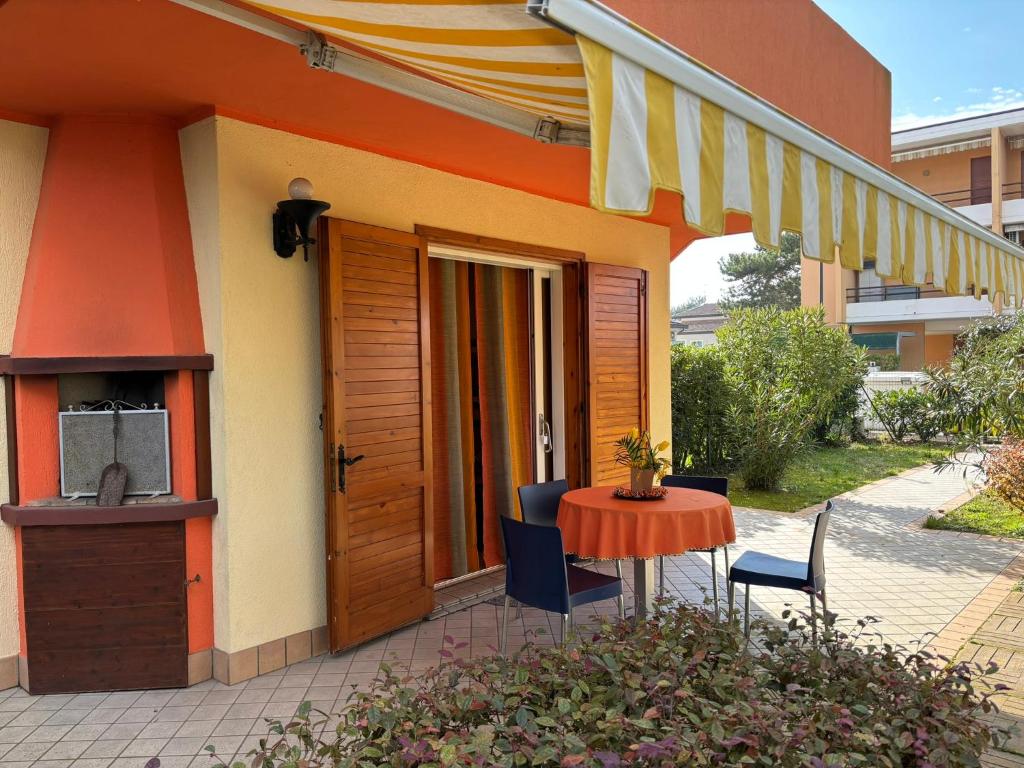 a table and chairs sitting outside of a house at Villa Atlante in Bibione