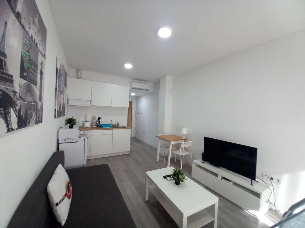 a living room with a couch and a tv and a table at Apartamento n3, a 10 min del aeropuerto in San Fernando de Henares
