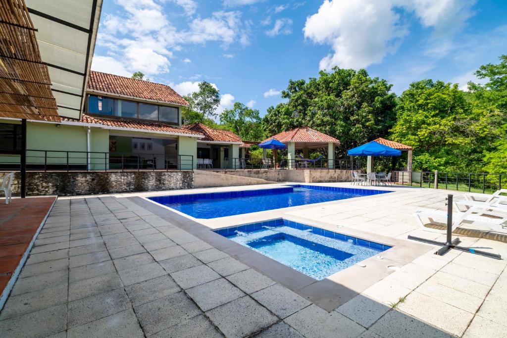 a swimming pool in the backyard of a home with a house at Casa Matiz - Vistas increíbles cerca de Anapoima in Apulo