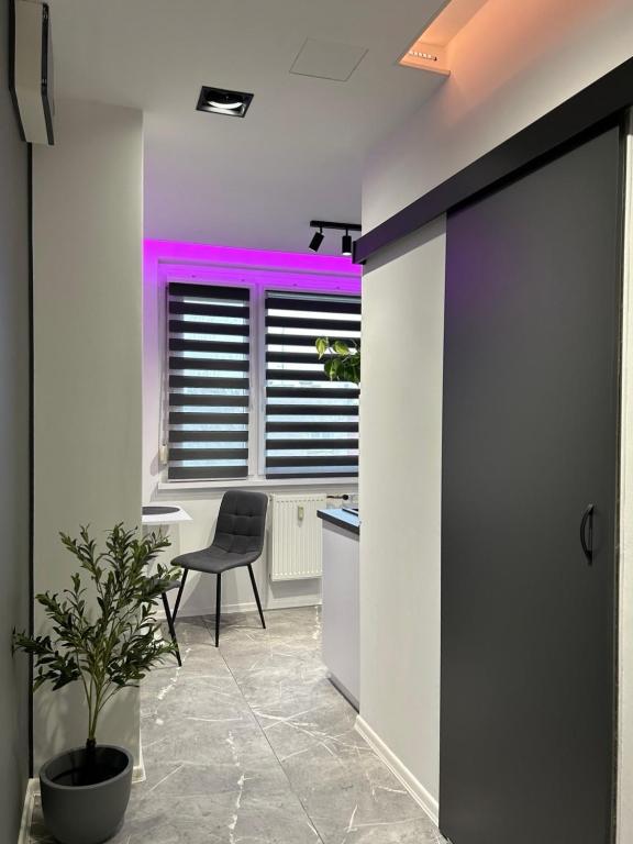 an office with a chair and a desk and a window at Block Home Apartman in Makó