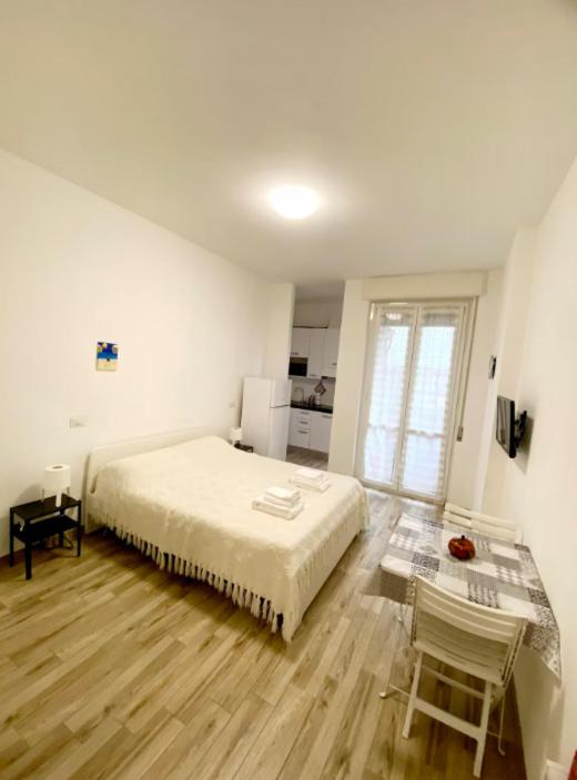 a white bedroom with a bed and two chairs at "Suite Sesto" Metro M1 to Milano, Rho Fiera, Monza in Sesto San Giovanni