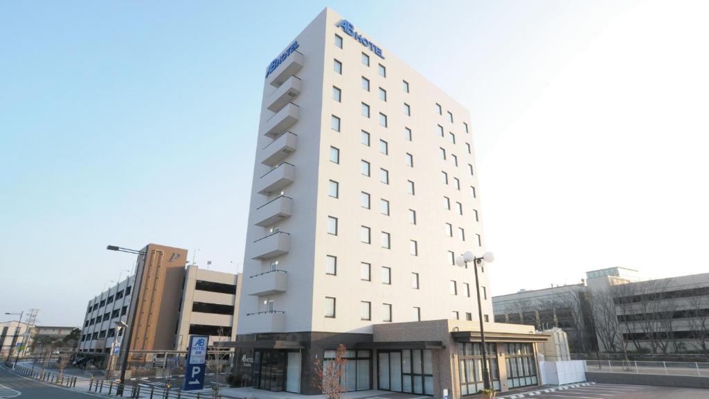 un alto edificio bianco su una strada con edifici di AB Hotel Tahara a Tahara